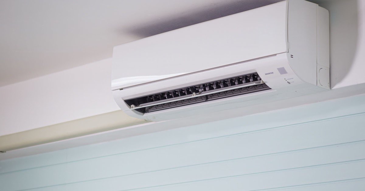 Wit binnentoestel van een airco hoog aan de muur