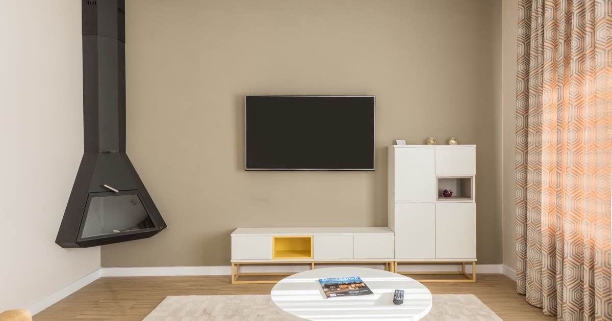 Lichte woonkamer met hangende haard, tv-meubel en ronde salontafel