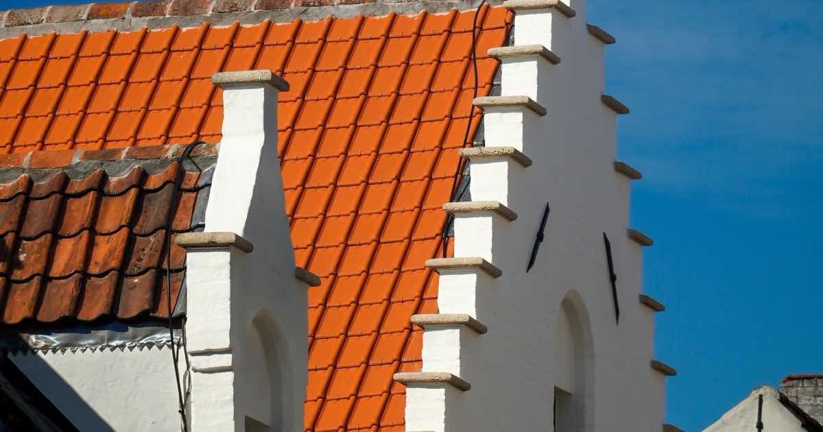 Rood pannendak naast een witte trapgevel